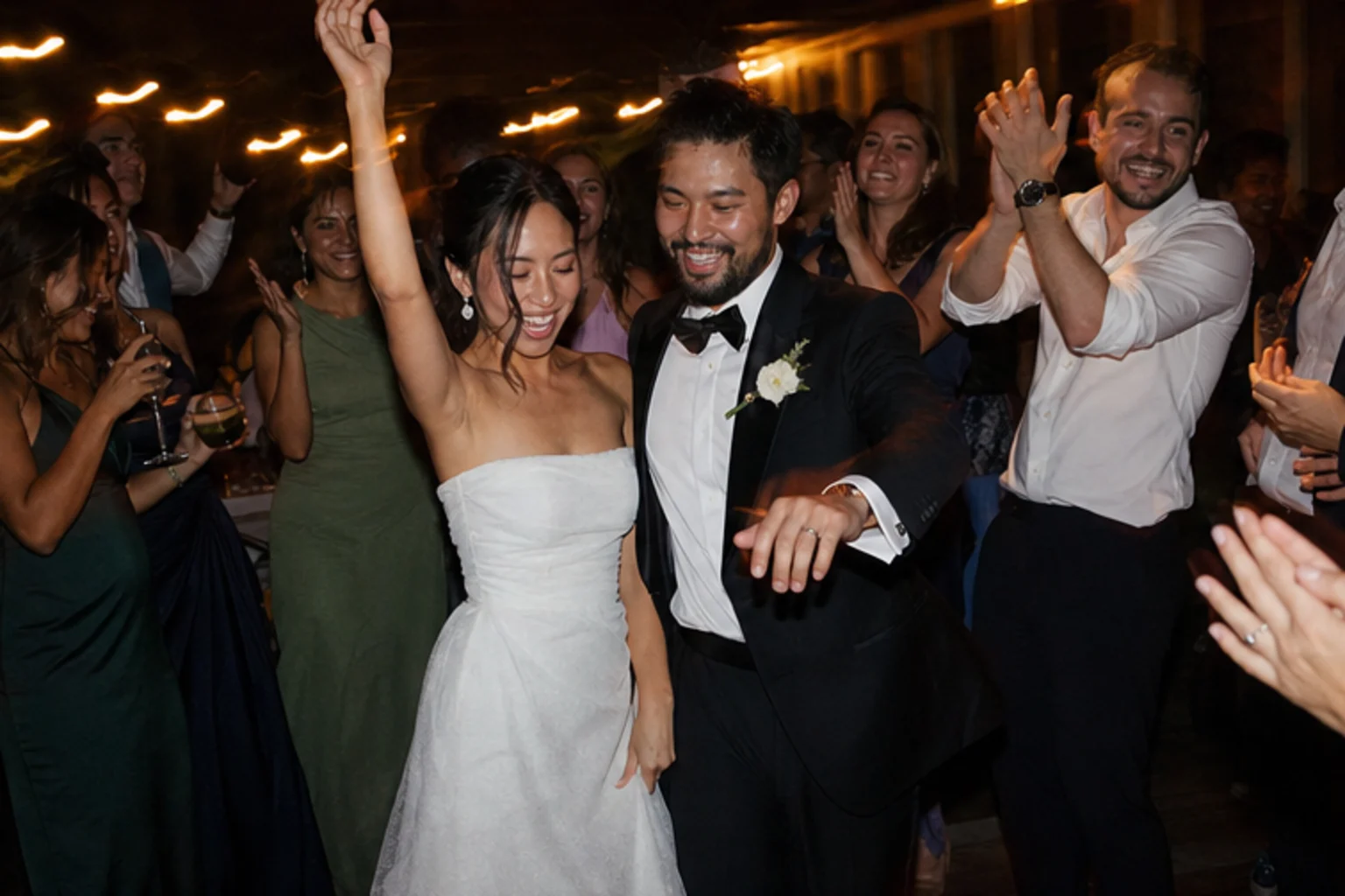 Newlyweds dancing among friends