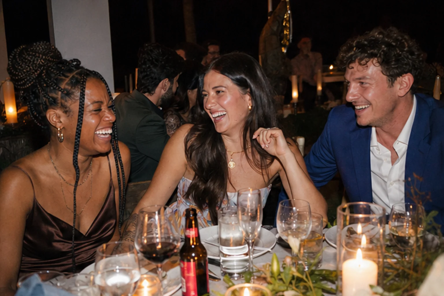 Friends gathered around a flash-lit wedding table